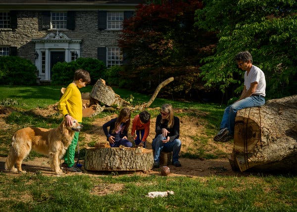 Dylan Omary, 11, from left, alongside his sister, Layla, 8, brother Wyatt, 8, mother, Lesley, and father, Reed, explore a large downed tree in front of a neighbor’s yard in Nashville, Tenn.