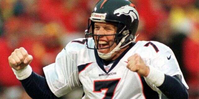 Denver Broncos quarterback John Elway celebrates a touchdown by teammate Terrell Davis.