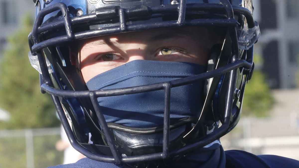 A Herriman player wear a mask during a high school football against Davis on Thursday, Aug. 13, 2020, in Herriman, Utah. Utah is among the states going forward with high school football this fall despite concerns about the ongoing COVID-19 pandemic that led other states and many college football conferences to postpone games in hopes of instead playing in the spring. (AP Photo/Rick Bowmer)